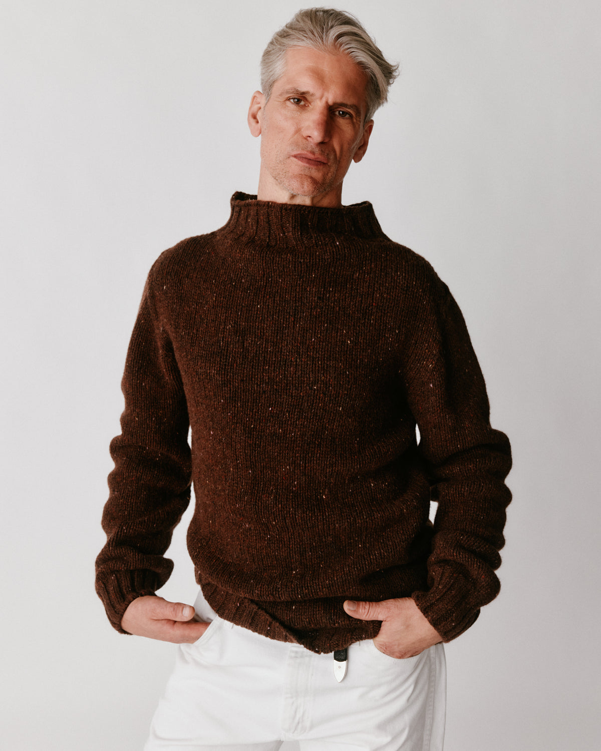 A model wearing a Bosie Blue Mogganer Glenugie Nep Funnel Neck Lighthouse Sweater in colour Monach.
