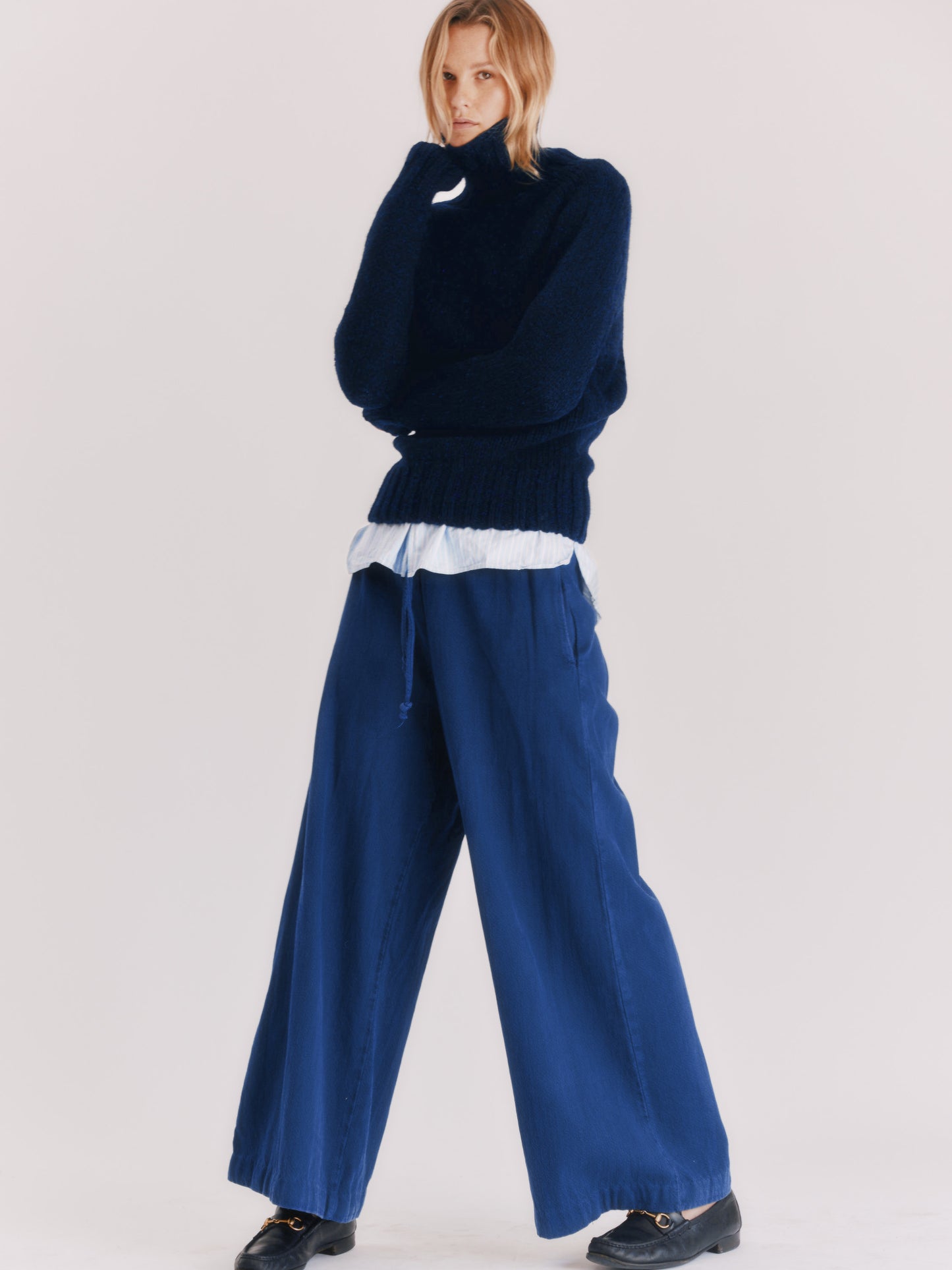 Woman wearing a Blue Mogganer Cosmos Navy Siren fishermas chunky roll polo neck in Geelong merino by Bosie Knitwear.