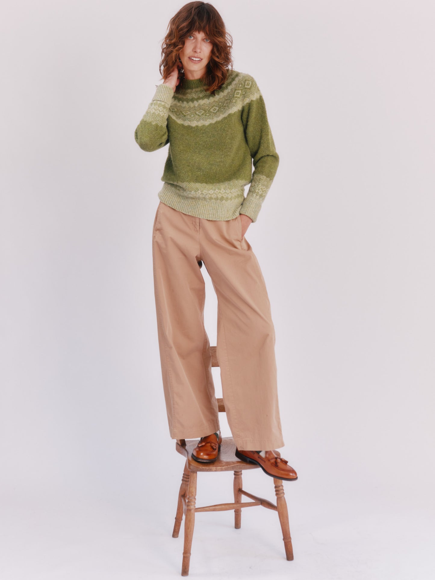 Model wearing a Bosie Knitwear Borealis Yoke Brushed Fair Isle Women's Lambswool Sweater in colour Olive Grove Green.