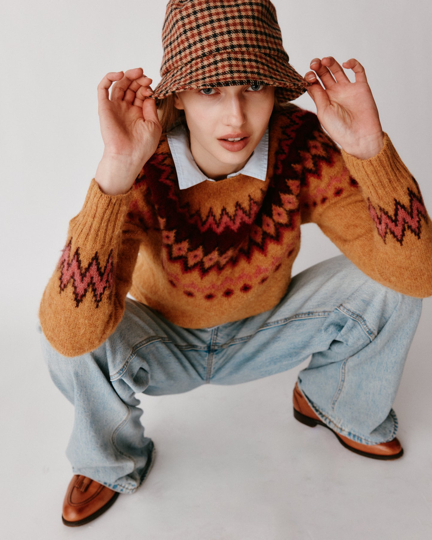A model wearing a Bosie Fjord Yoke Brushed Fair Isle Women's Lambswool Sweater in colour Gold Dust / Cummin.