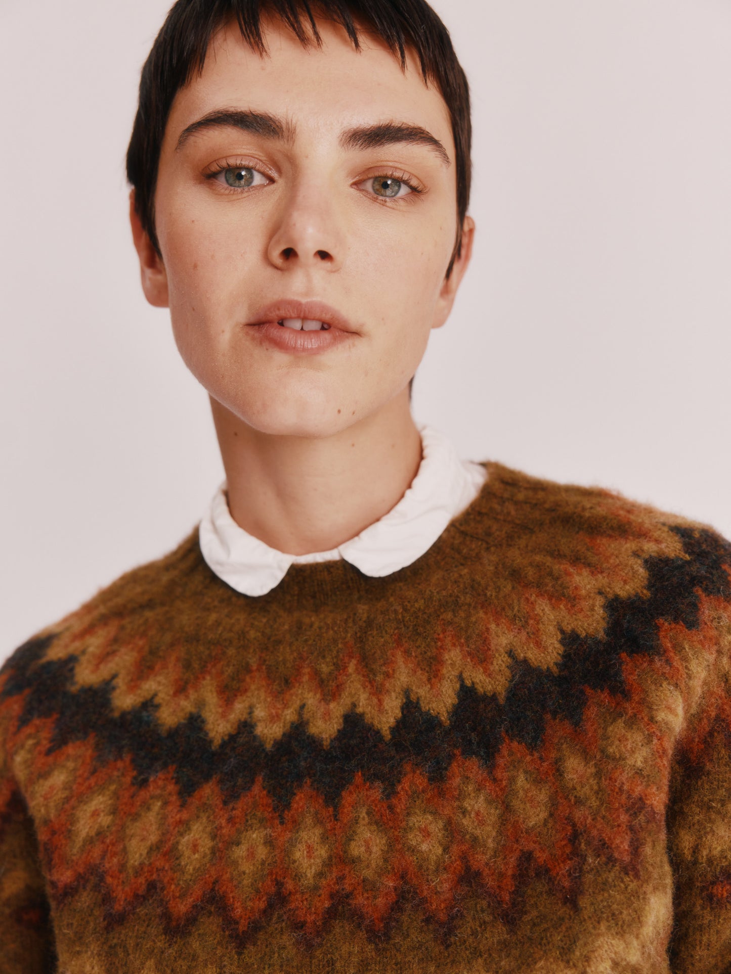 Model wearing a Bosie Knitwear Fjord Yoke Brushed Fair Isle Women's Lambswool Sweater in colour Dark Olive.