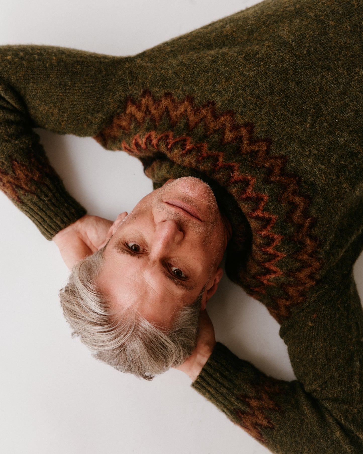 A model wearing a Bosie Glacier Yoke Brushed Fair Isle Men's Sweater in colour Scots Pine / Pineshadow.