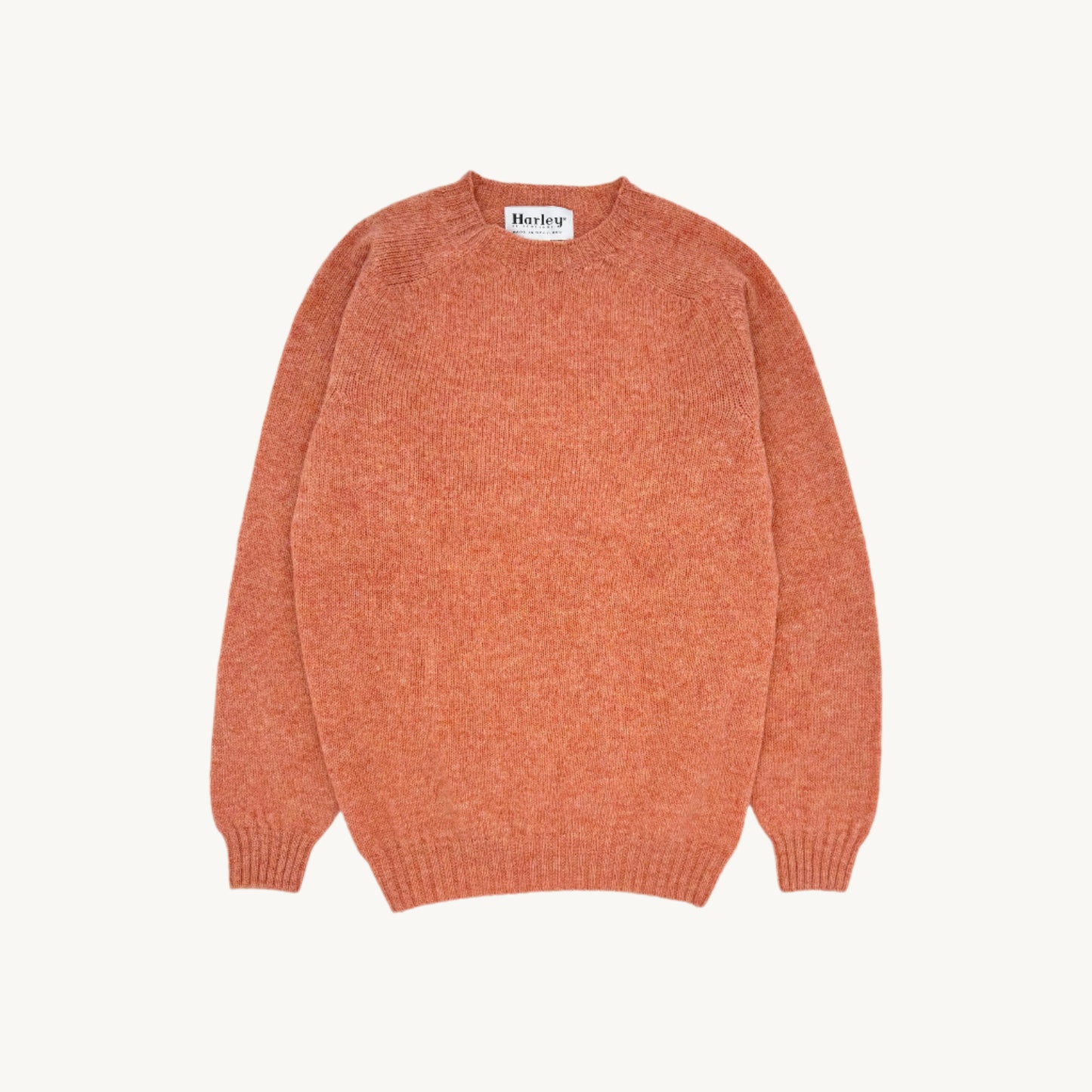 Flatbed photograph of harley of scotland mens seamless saddle shoulder shetland sweater in colour parfait peach.