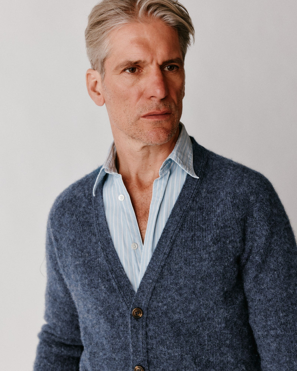Man wearing the Bosie Harley of Scotland Shaggy Shetland V Cardigan in Denim – seamless, seam-free pure wool, knitted in Scotland by Harley of Scotland
