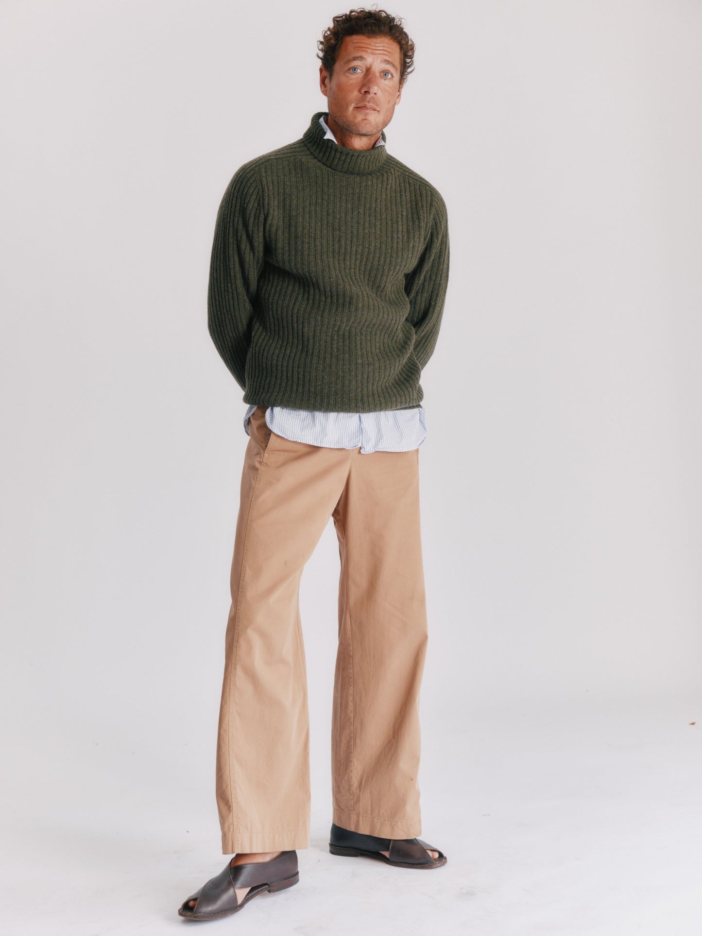 Man wearing a Blue Mogganer Diver loden green ribbed polo neck Geelong Sweater by Bosie Knitwear