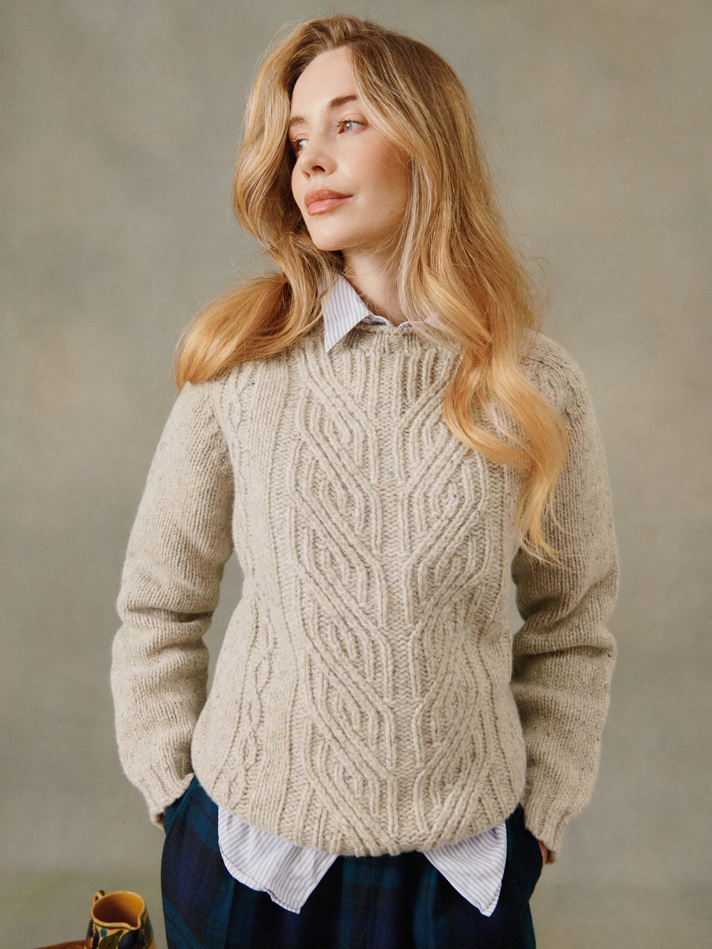 Woman wearing a women's Glenugie Nep Braid cable stitch effect sweater jumper in Mull Natural
