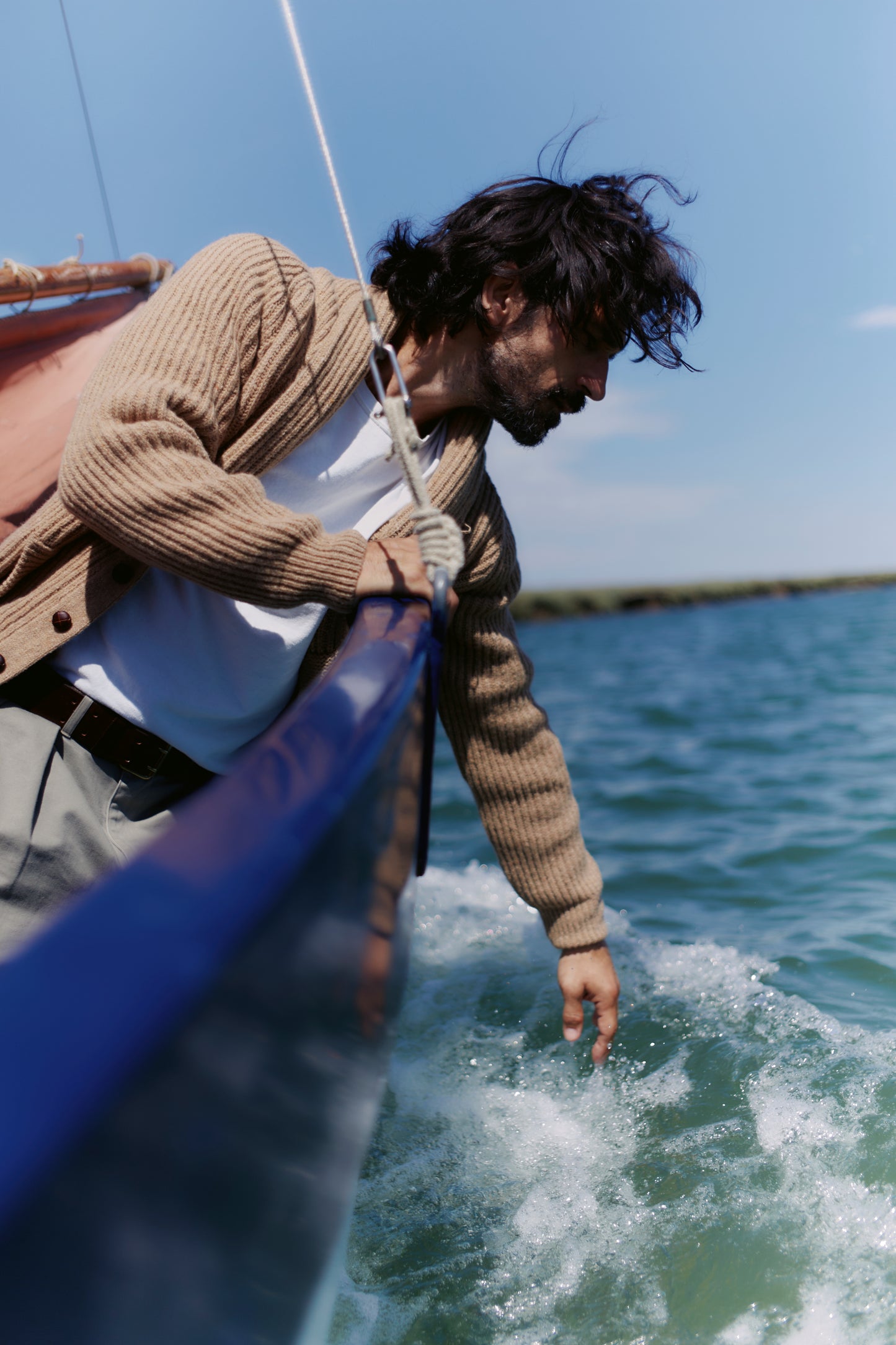 Man on boat wearing a Bosie Blue Mogganer Harbourmaster Cardigan in Sanday Camel