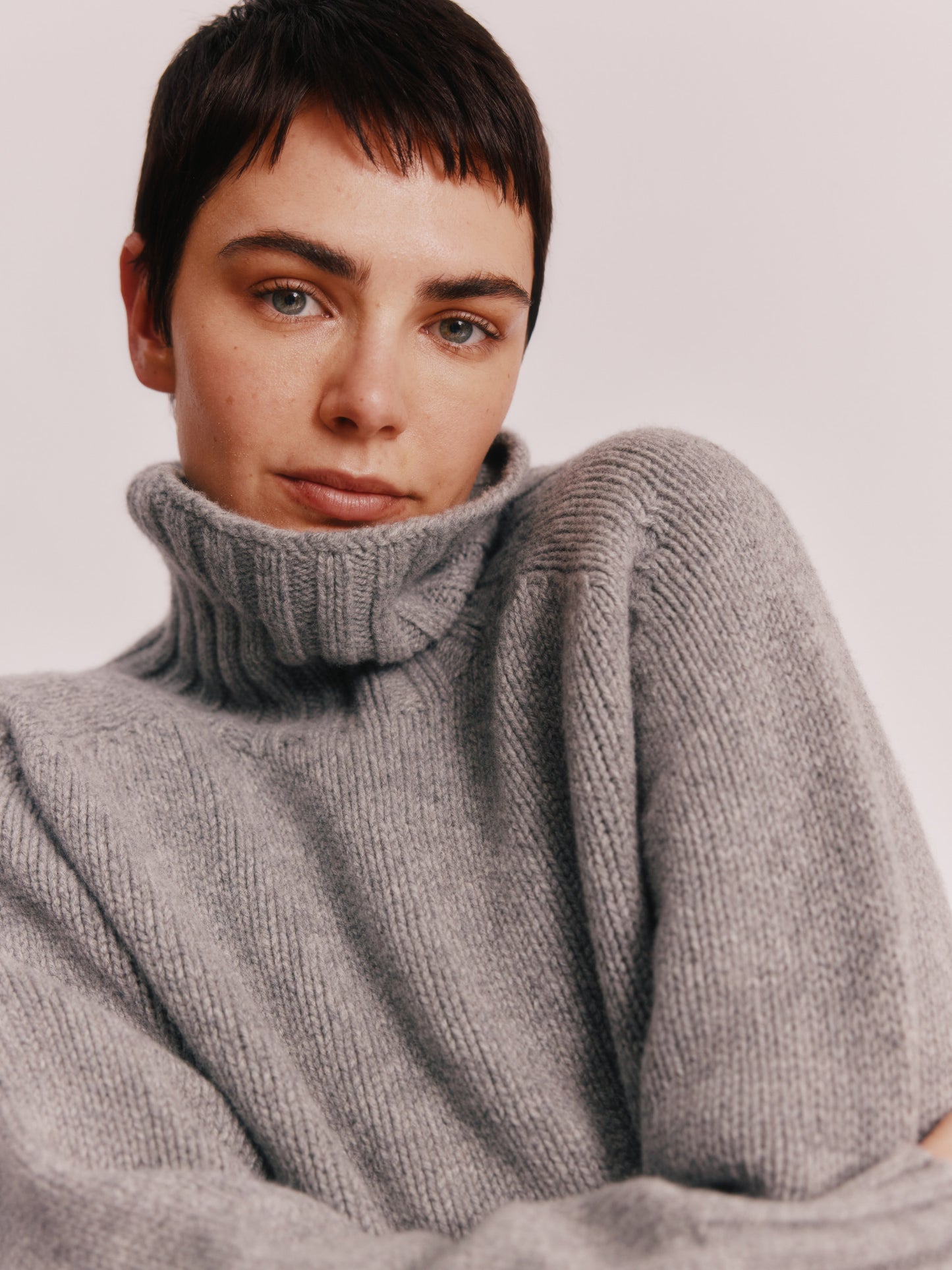 Model wearing a Bosie Knitwear Blue Mogganer Womens Siren Merino Polo Neck Sweater in colour Flannel Grey.