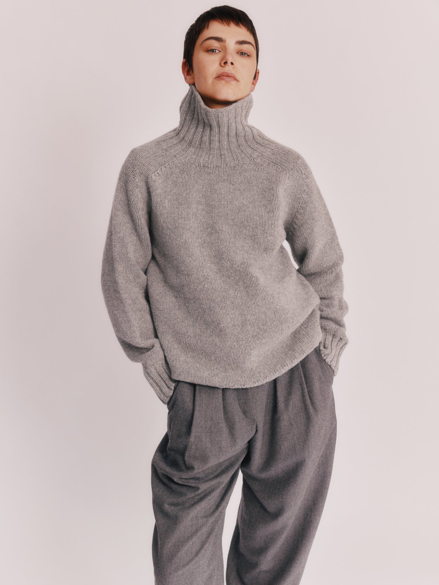 Model wearing a Bosie Knitwear Blue Mogganer Womens Siren Merino Polo Neck Sweater in colour Flannel Grey.