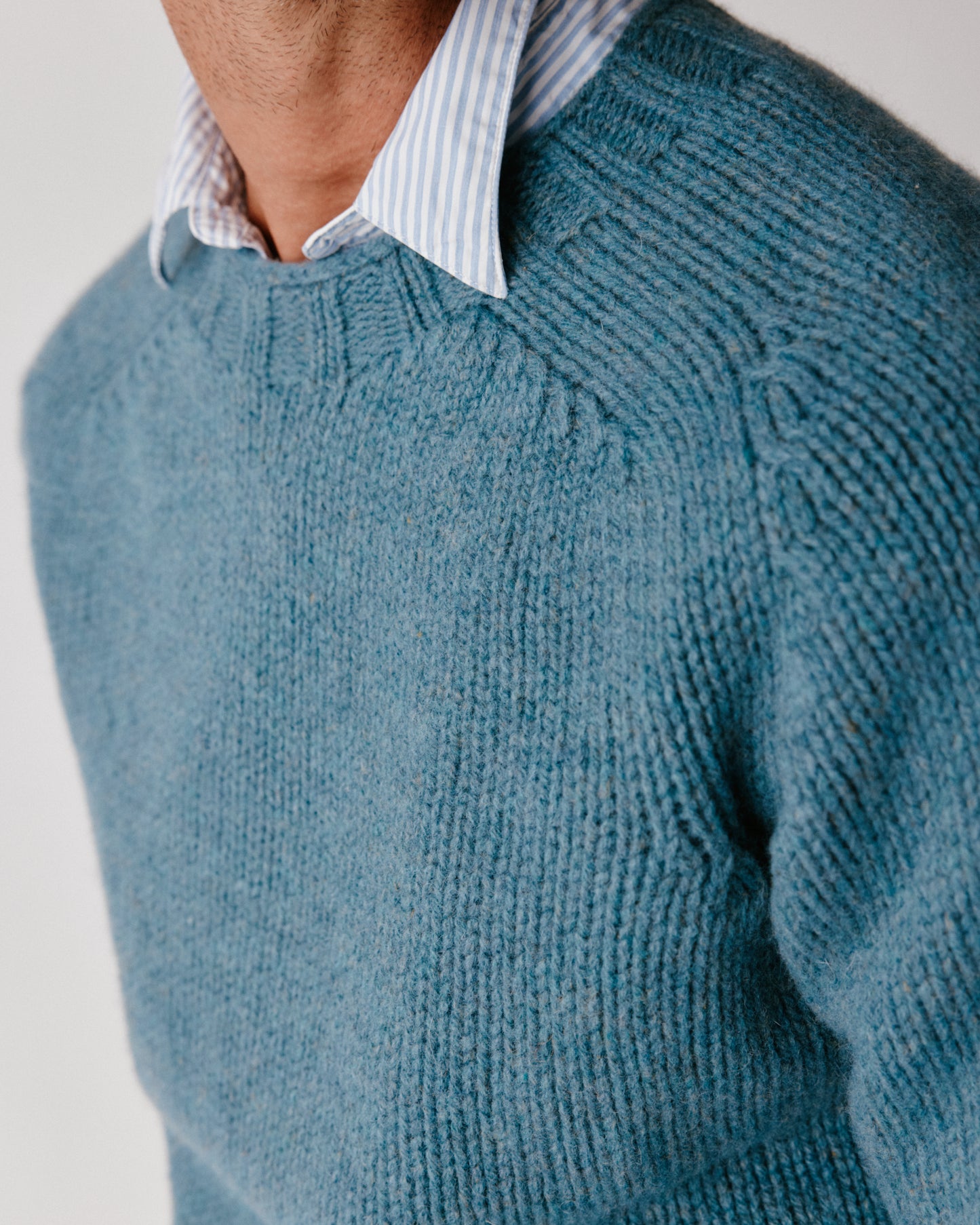 A model wearing a Bosie Blue Mogganer Explorer Extra Chunky Seamless Supersoft Shetland Sweater in colour Cirrus.
