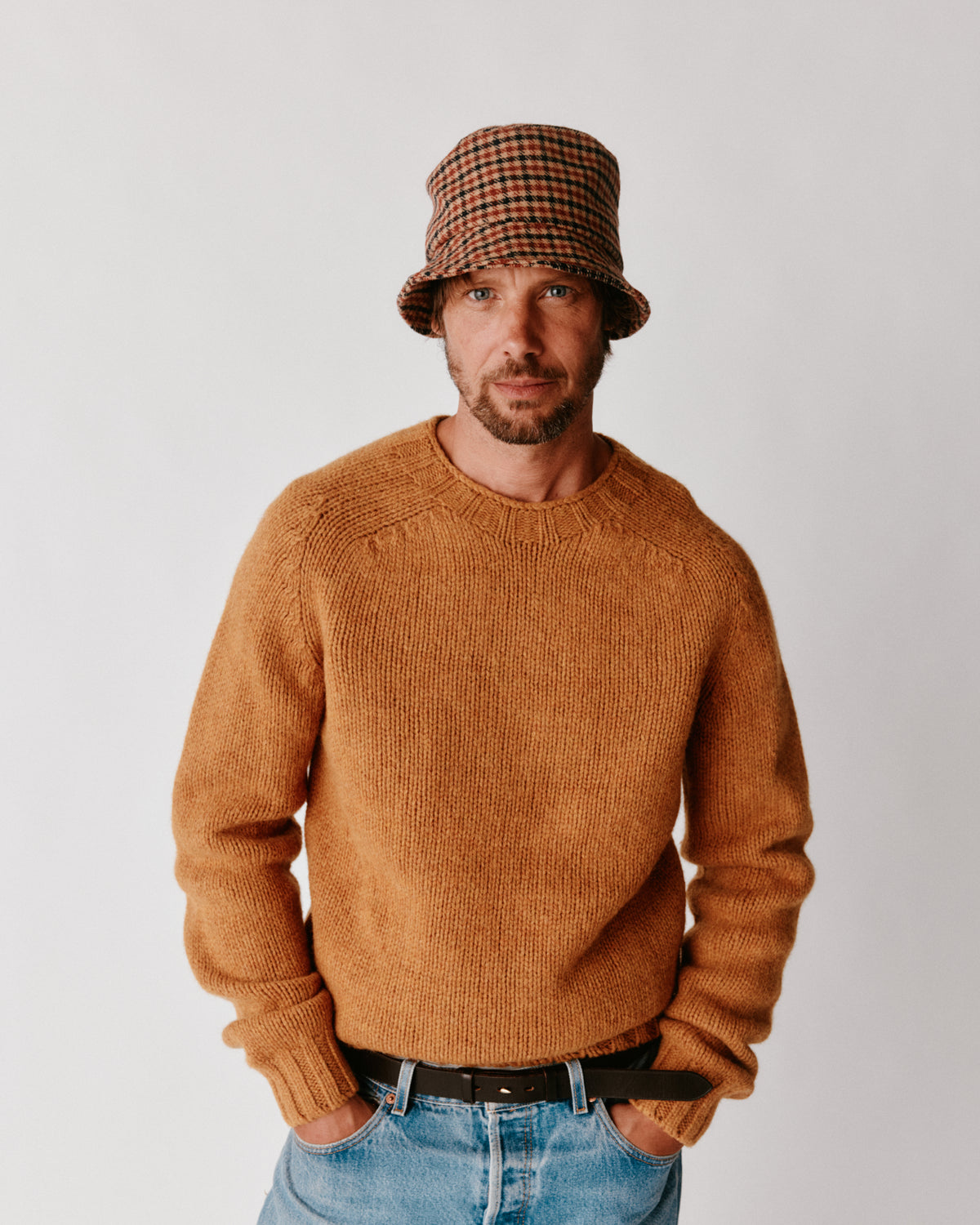 A model wearing a Bosie Blue Mogganer Explorer Extra Chunky Seamless Supersoft Shetland Sweater in colour Gold Dust / Cummin.