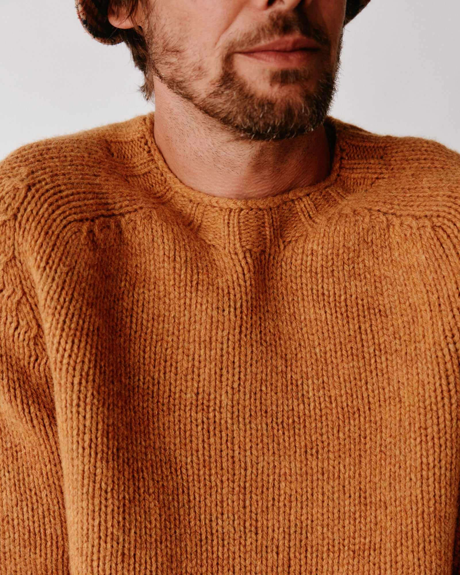 A model wearing a Bosie Blue Mogganer Explorer Extra Chunky Seamless Supersoft Shetland Sweater in colour Gold Dust / Cummin.