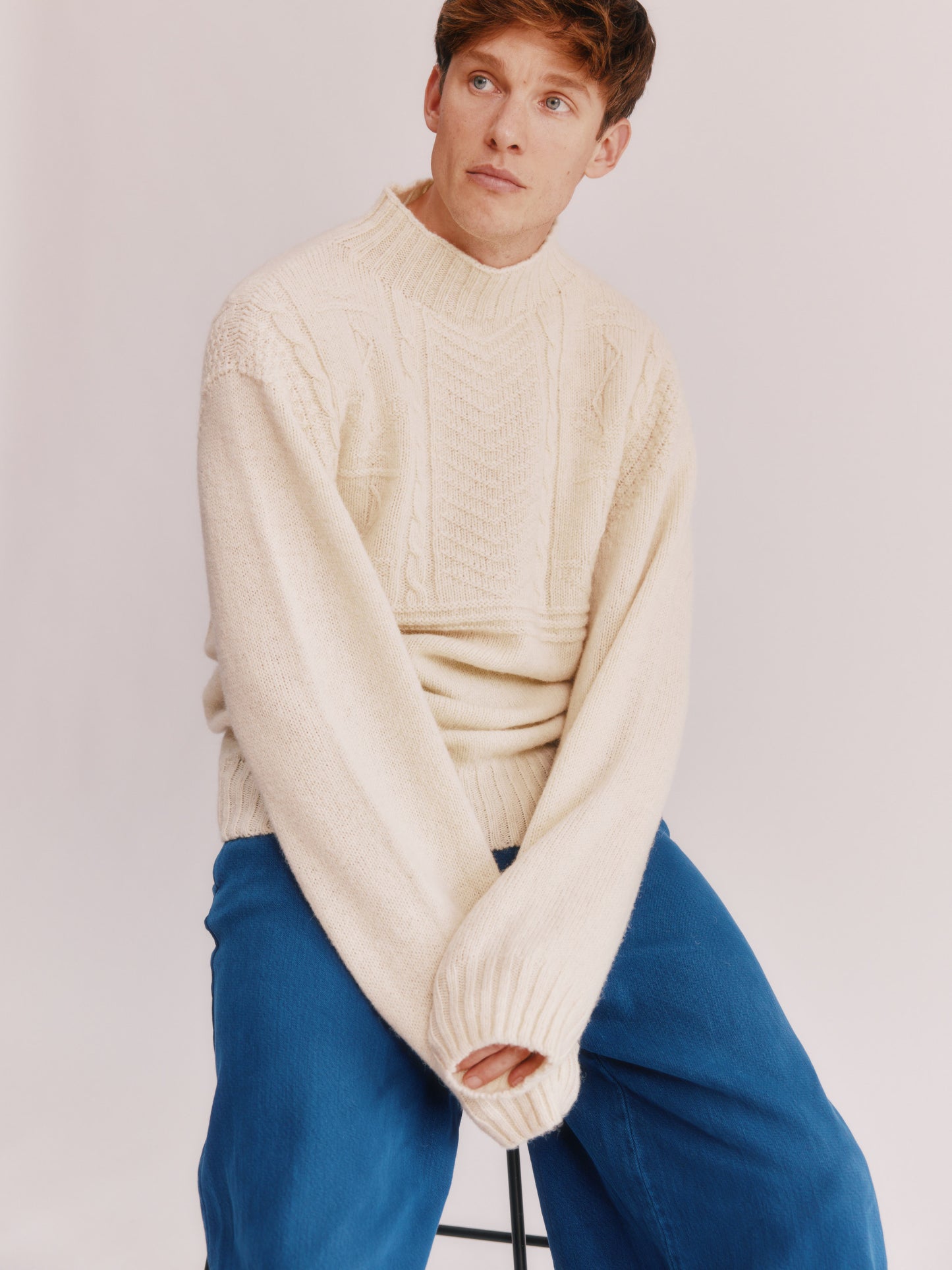 Model wearing a Bosie Knitwear Blue Mogganer Ganjey Heritage Heather Knoll Crew Neck Sweater in colour Ecru White.