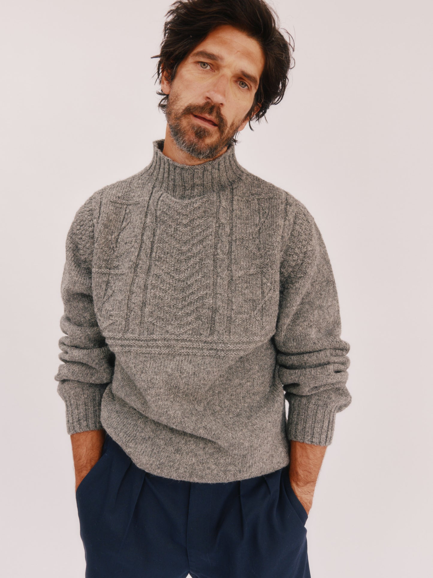 Model wearing a Bosie Knitwear Blue Mogganer Ganjey Heritage Heather Knoll Crew Neck Sweater in colour Med Grey.