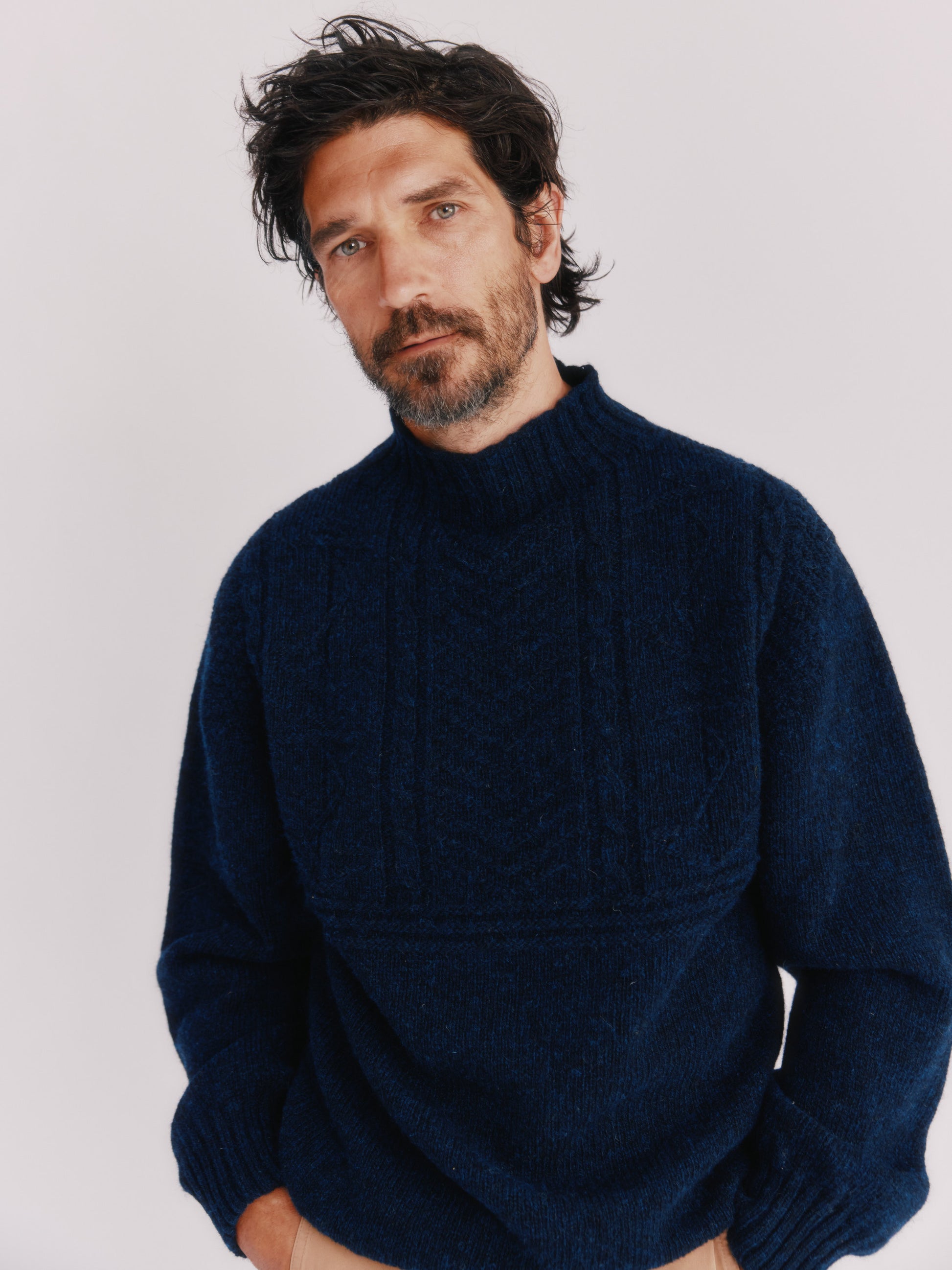 Model wearing a Bosie Knitwear Blue Mogganer Ganjey Heritage Heather Knoll Crew Neck Sweater in colour Navy. 