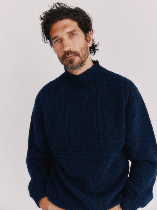 Model wearing a Bosie Knitwear Blue Mogganer Ganjey Heritage Heather Knoll Crew Neck Sweater in colour Navy. 