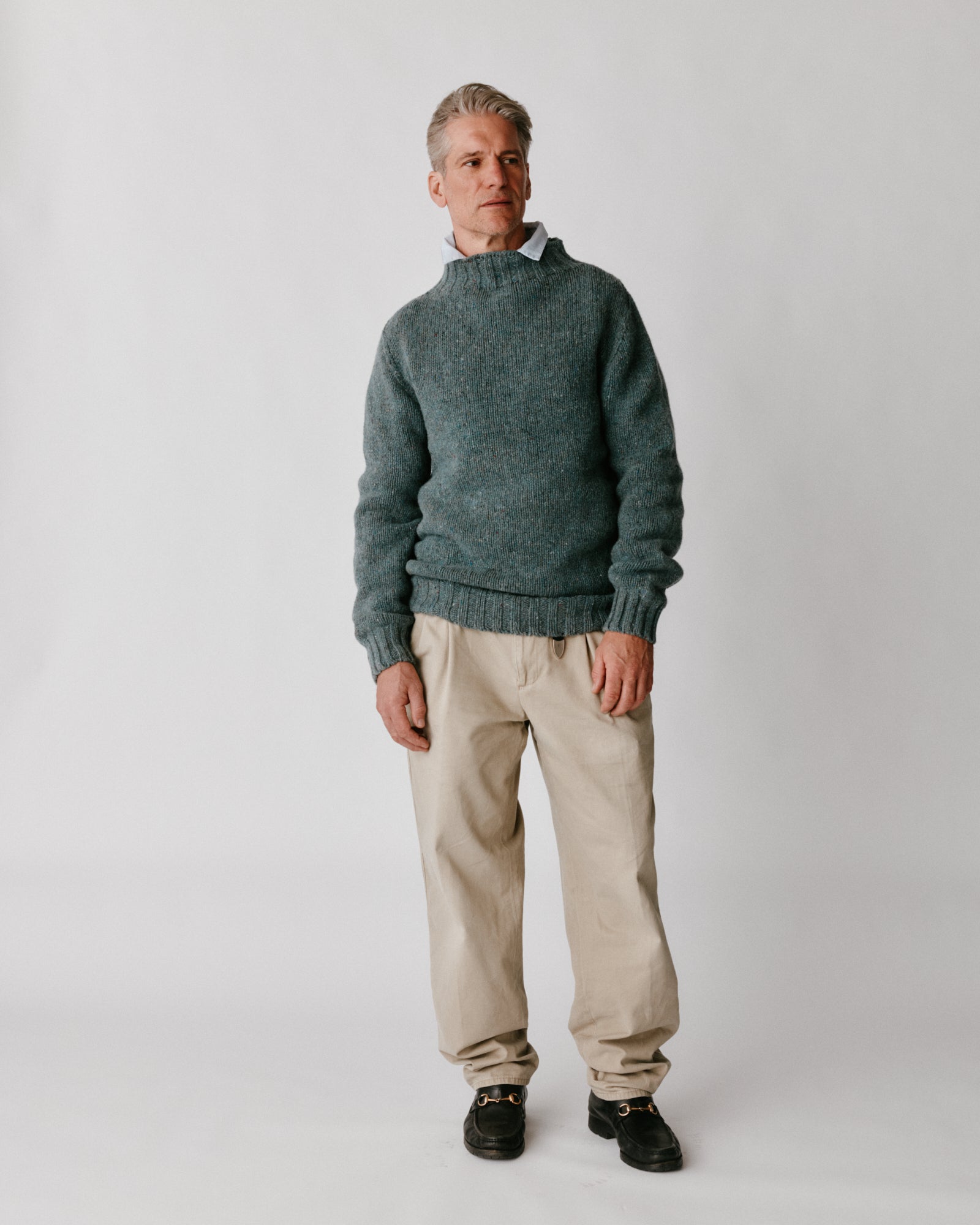 A model wearing a Bosie Blue Mogganer Glenugie Nep Funnel Neck Lighthouse Sweater in colour Lomond.