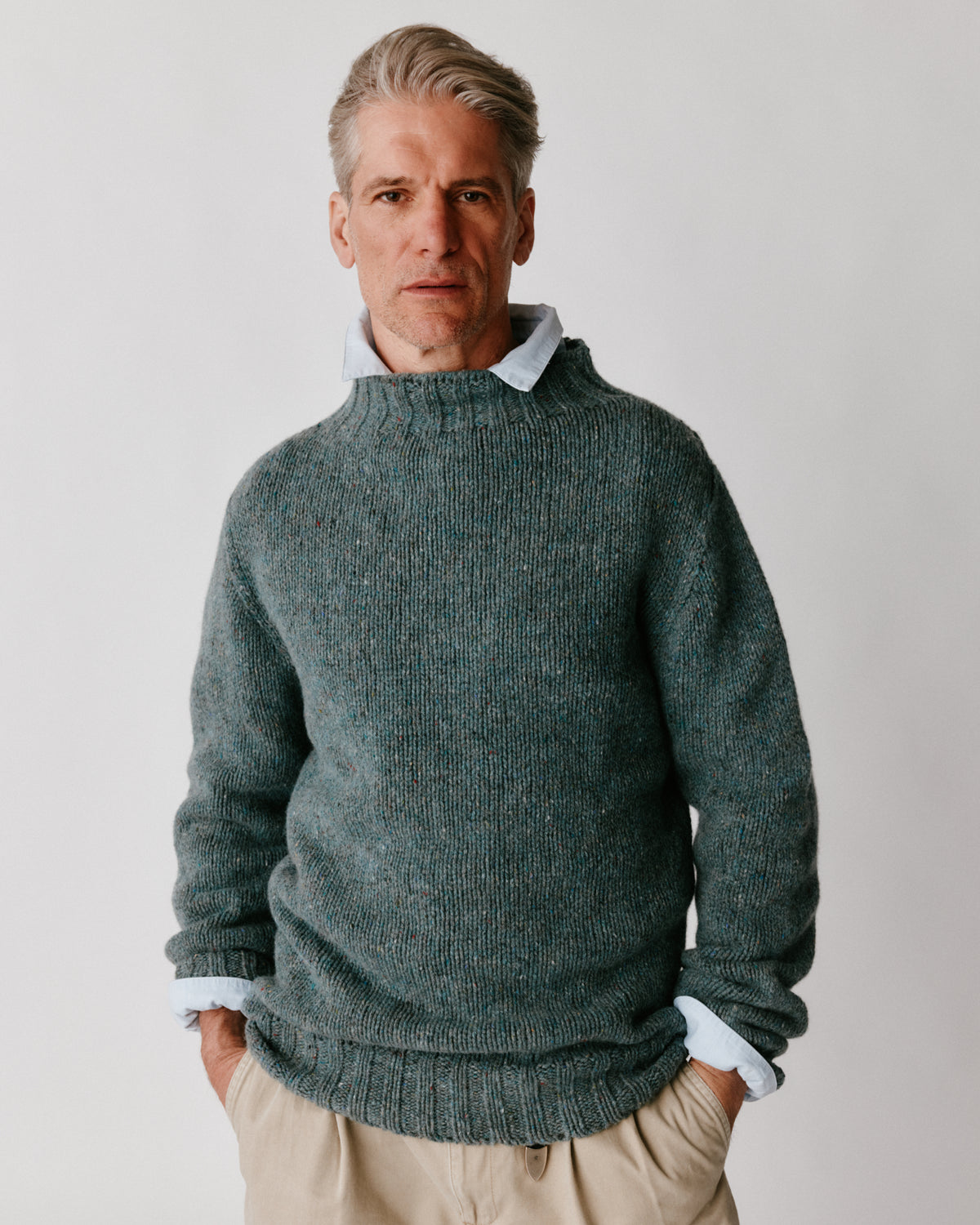 A model wearing a Bosie Blue Mogganer Glenugie Nep Funnel Neck Lighthouse Sweater in colour Lomond.