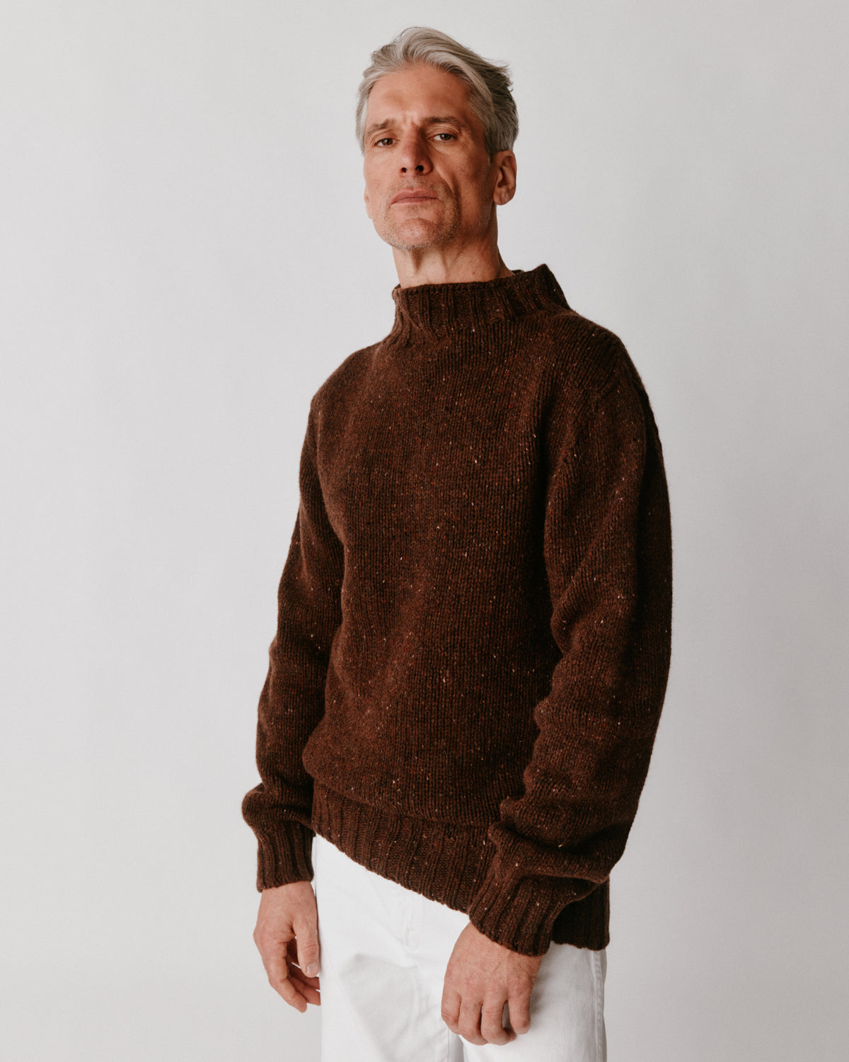 A model wearing a Bosie Blue Mogganer Glenugie Nep Funnel Neck Lighthouse Sweater in colour Monach.