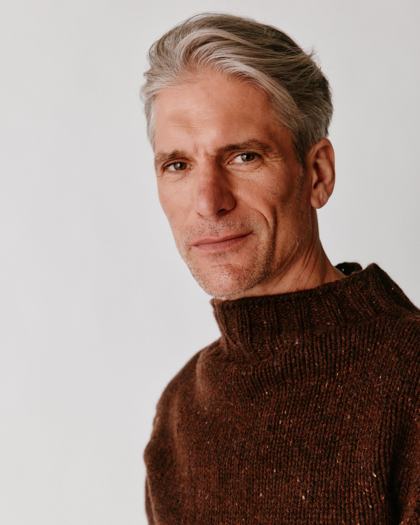 A model wearing a Bosie Blue Mogganer Glenugie Nep Funnel Neck Lighthouse Sweater in colour Monach.