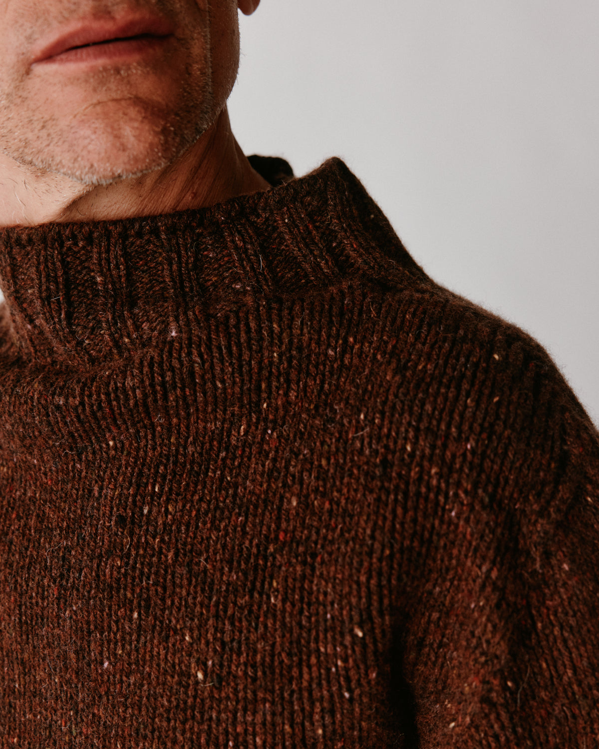 A model wearing a Bosie Blue Mogganer Glenugie Nep Funnel Neck Lighthouse Sweater in colour Monach.