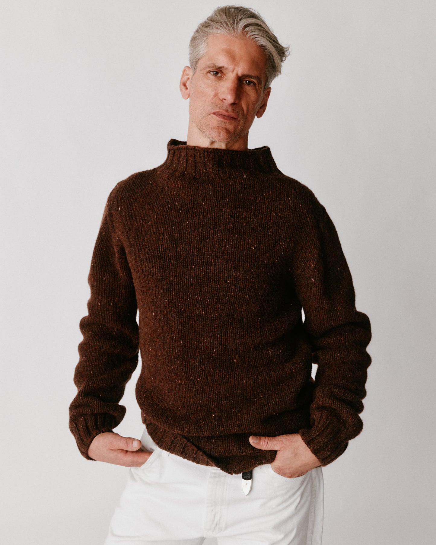 A model wearing a Bosie Blue Mogganer Glenugie Nep Funnel Neck Lighthouse Sweater in colour Monach.