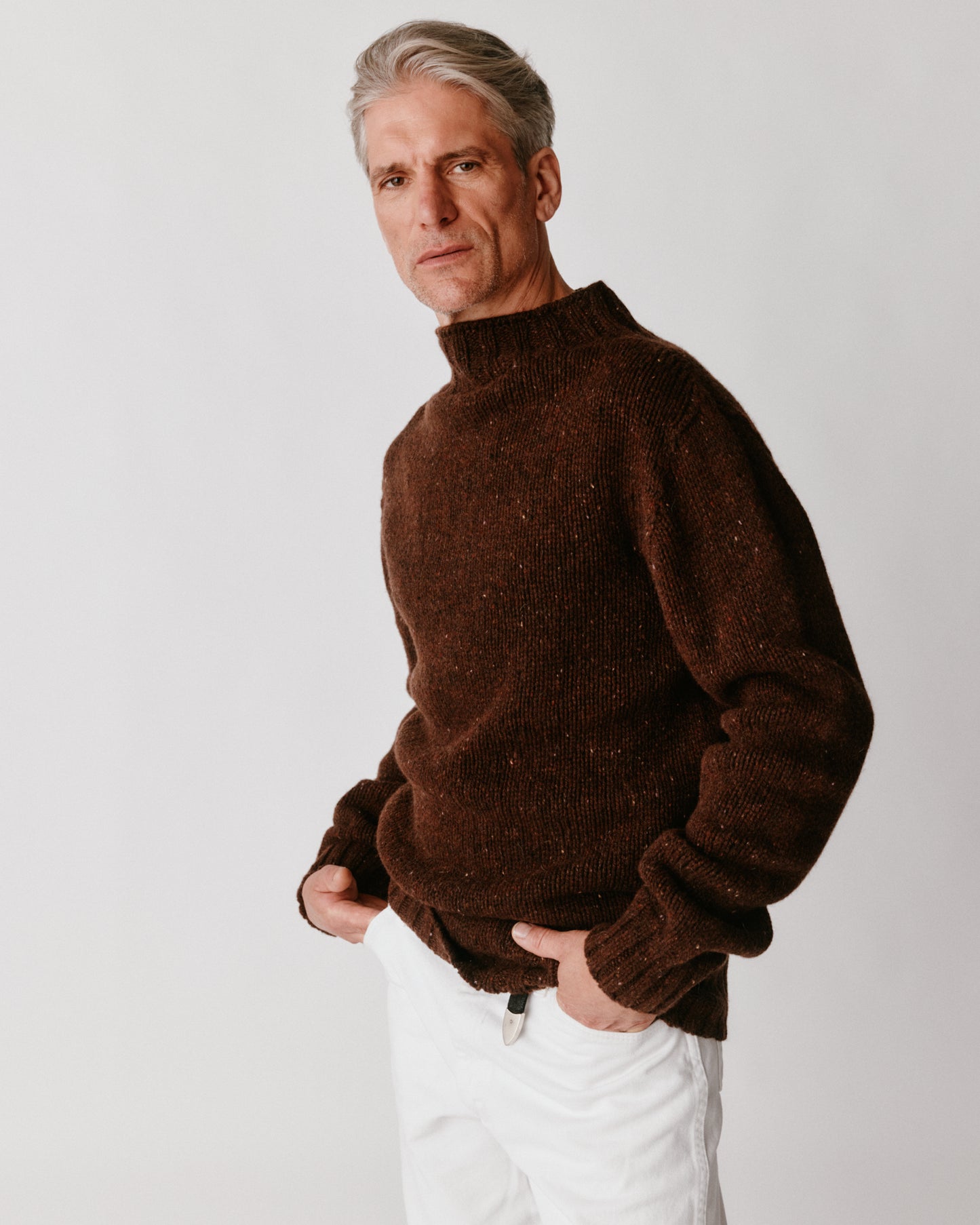 A model wearing a Bosie Blue Mogganer Glenugie Nep Funnel Neck Lighthouse Sweater in colour Monach.