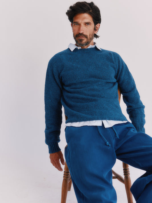 Flatbed photograph of a Bosie Knitwear Blue Mogganer Helmsman Glenugie Nep Sweater in colour Soay Blue.