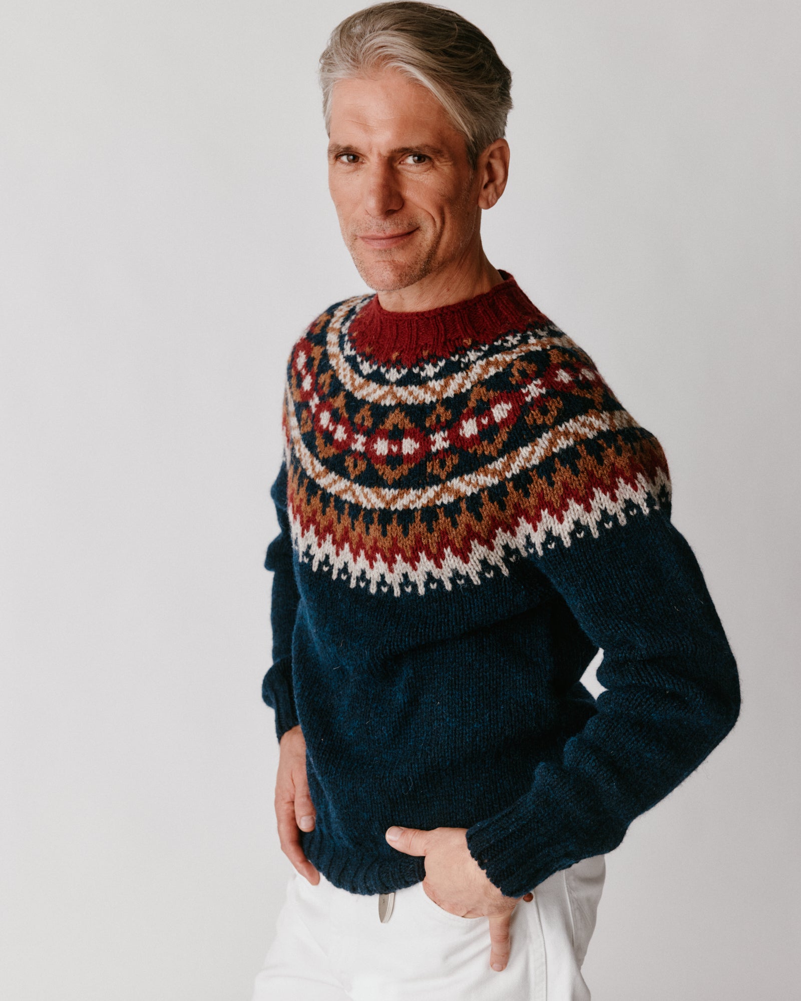 A model wearing a Bosie Blue Mogganer Northeaster Fairisle Yoke Chunky Ecology British Wool in colour Yew Navy.