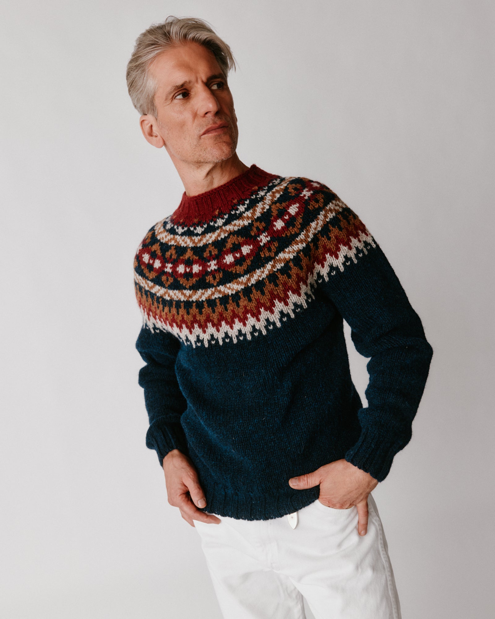 A model wearing a Bosie Blue Mogganer Northeaster Fairisle Yoke Chunky Ecology British Wool in colour Yew Navy.