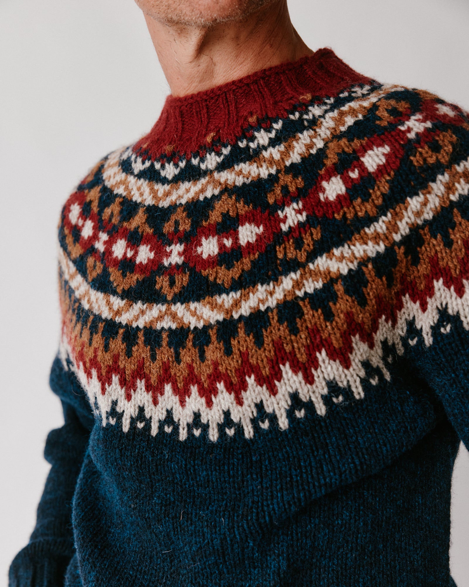 A model wearing a Bosie Blue Mogganer Northeaster Fairisle Yoke Chunky Ecology British Wool -in colour Yew Navy.
