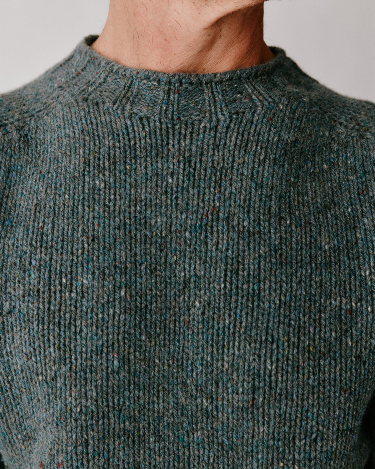 A model wearing a Bosie Blue Mogganer Trawlerman Chunky Glenugie Nep Sweater in colour Lomond.