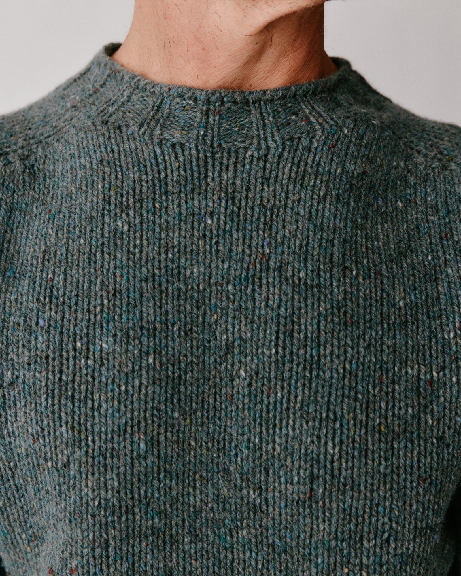 A model wearing a Bosie Blue Mogganer Trawlerman Chunky Glenugie Nep Sweater in colour Lomond.