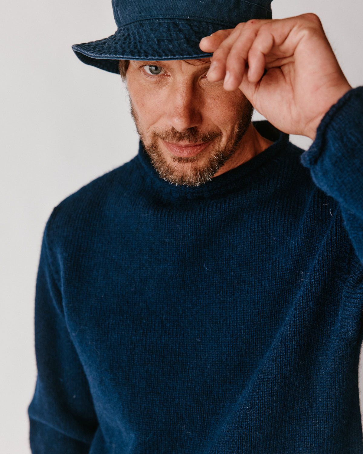 A model wearing a Bosie Blue Mogganer Whaler Rolled Neck Chunky Sweater in colour Navy.