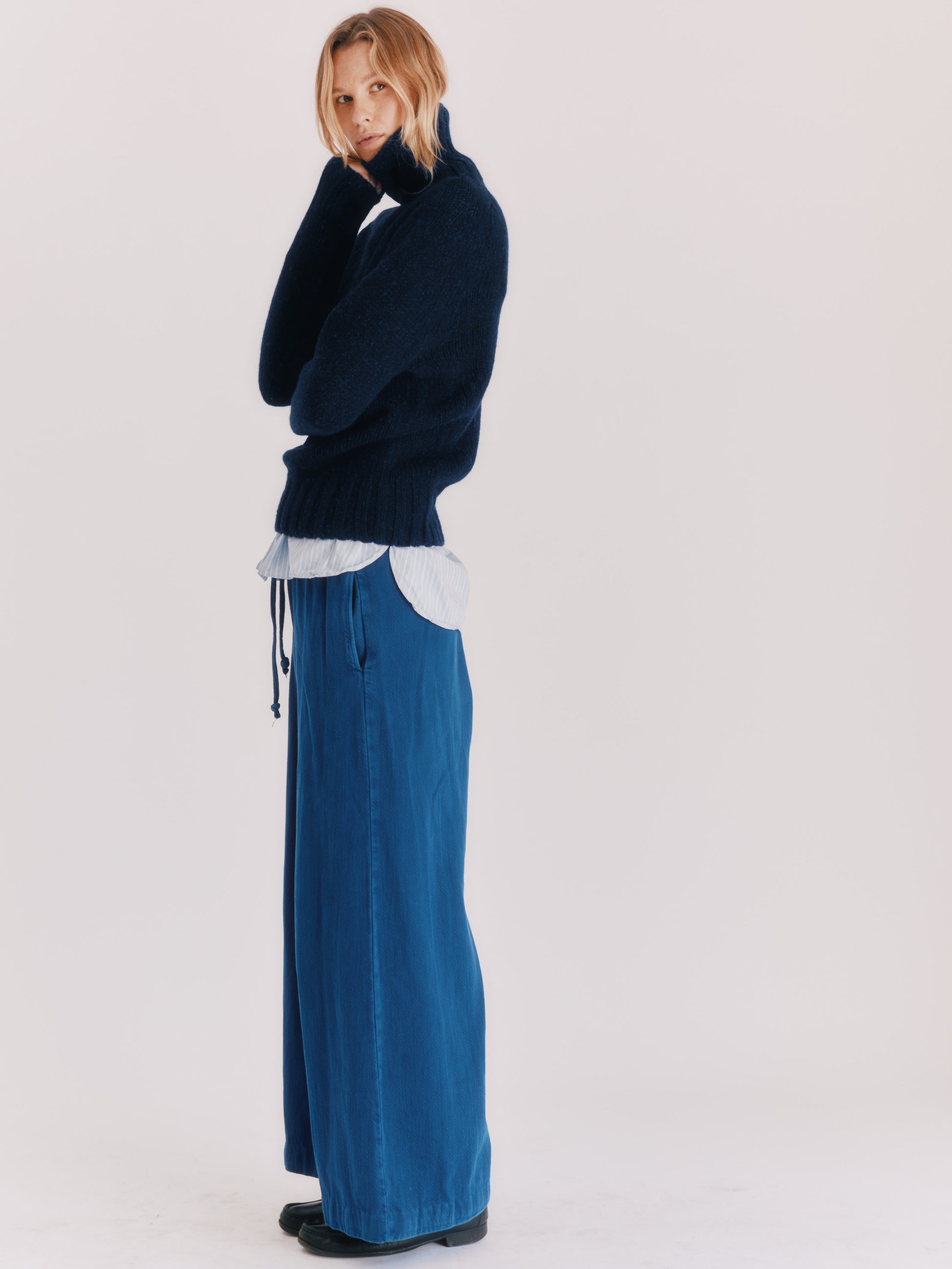 Woman wearing a Blue Mogganer Cosmos Navy Siren fishermas chunky roll polo neck in Geelong merino by Bosie Knitwear.