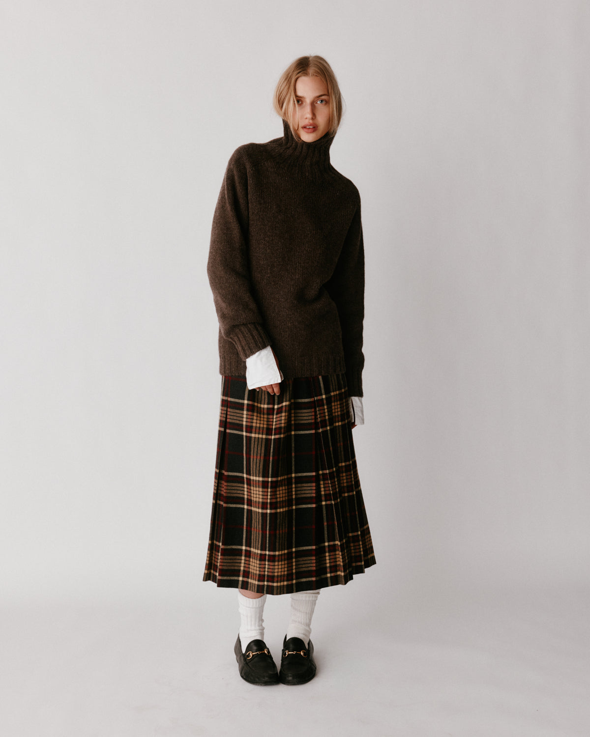 A model wearing a Bosie Blue Mogganer Womens Siren Merino Polo Neck Sweater in colour Porcupine.