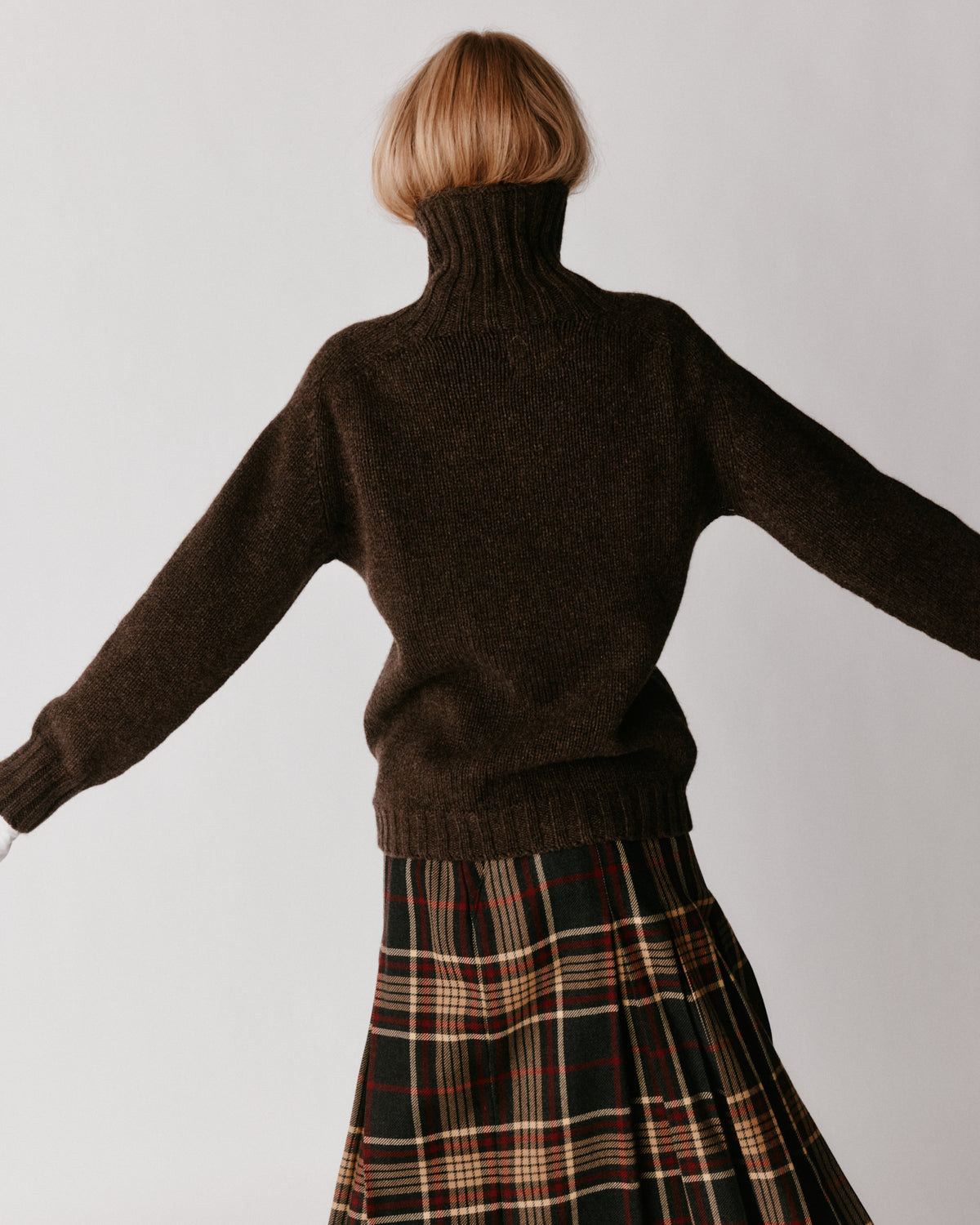 A model wearing a Bosie Blue Mogganer Womens Siren Merino Polo Neck Sweater in colour Porcupine.