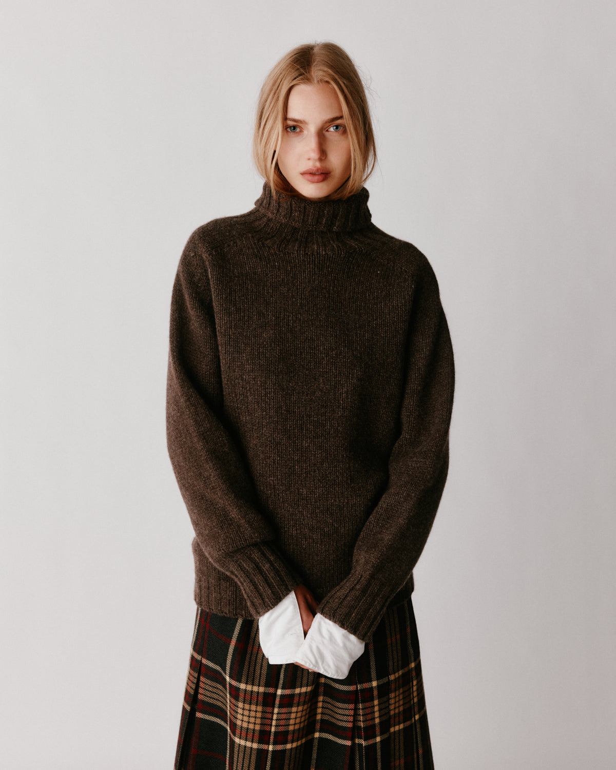 A model wearing a Bosie Blue Mogganer Womens Siren Merino Polo Neck Sweater in colour Porcupine.