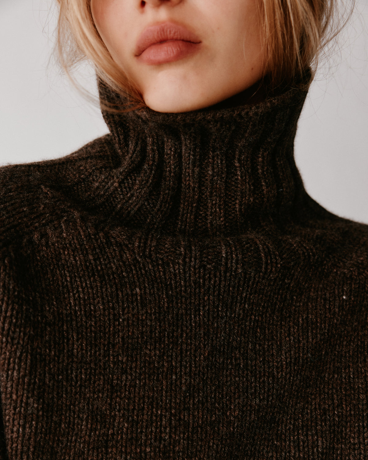 A model wearing a Bosie Blue Mogganer Womens Siren Merino Polo Neck Sweater in colour Porcupine.