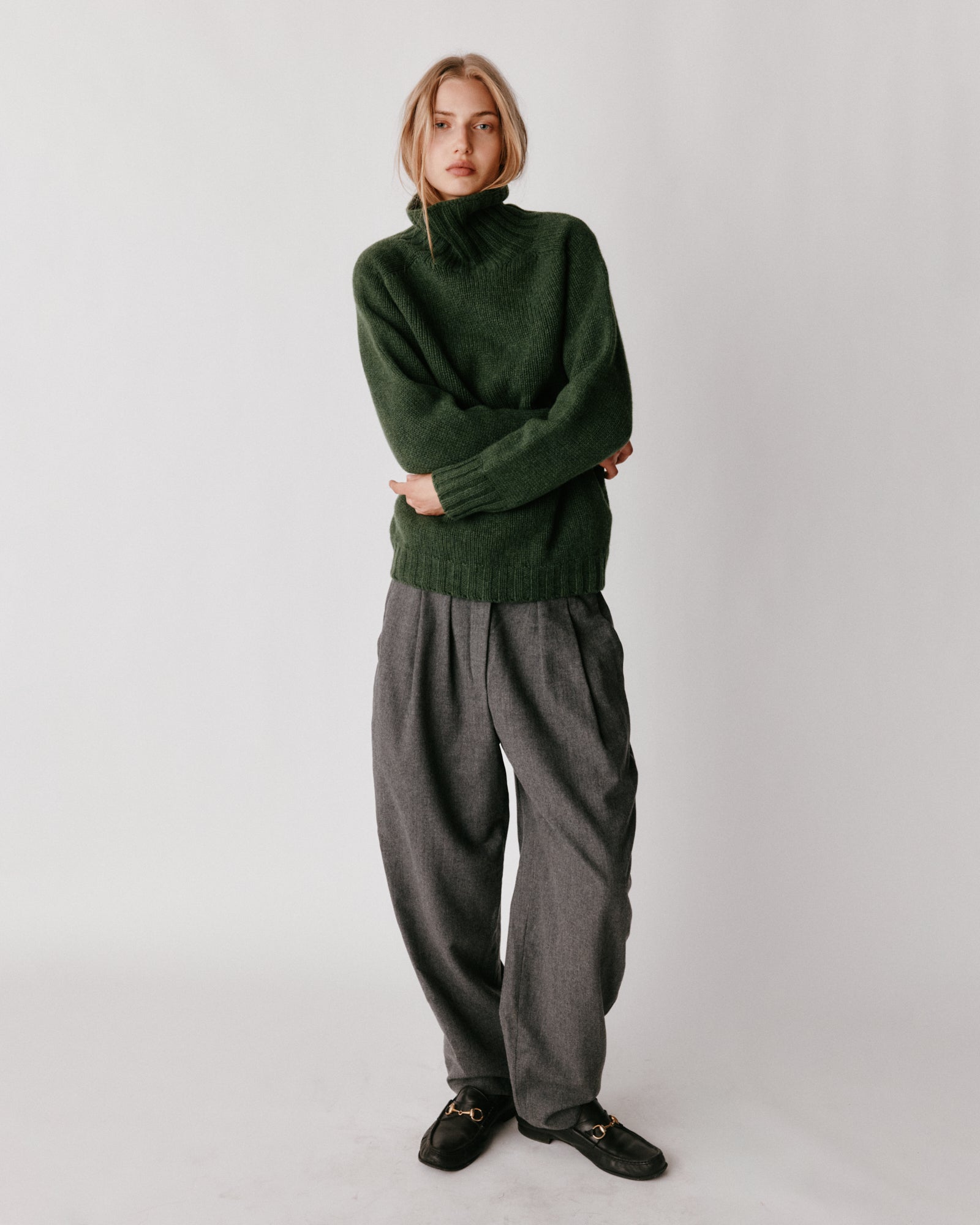 A model wearing a Bosie Blue Mogganer Womens Siren Merino Polo Neck Sweater in colour Serpentine.