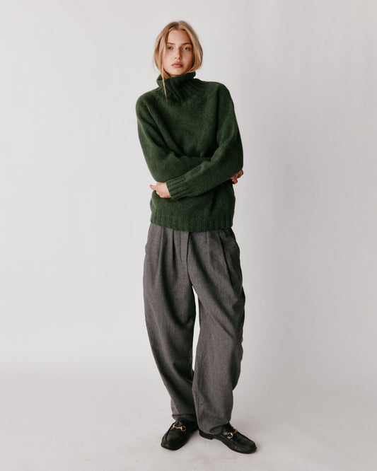 A model wearing a Bosie Blue Mogganer Womens Siren Merino Polo Neck Sweater in colour Serpentine.