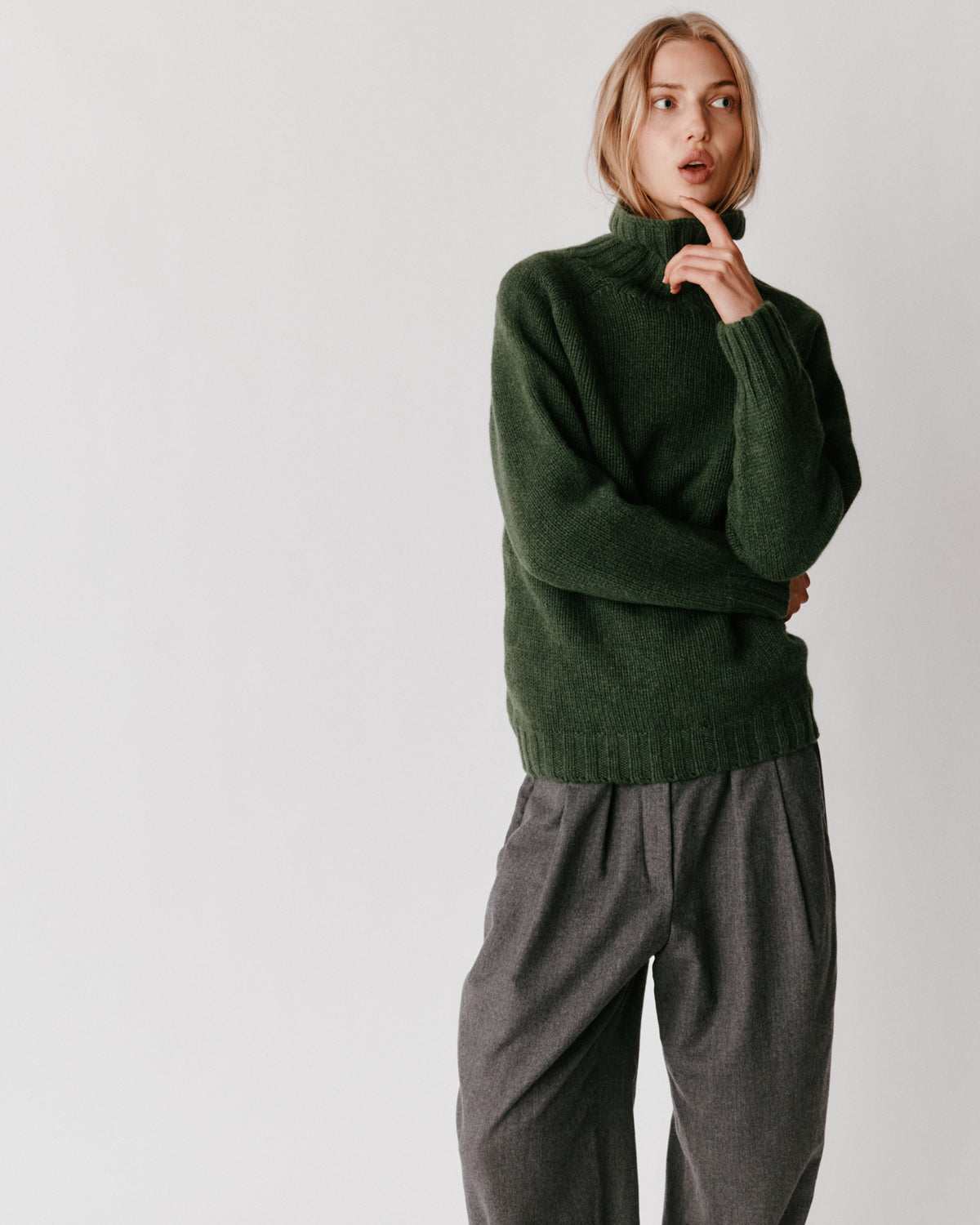 A model wearing a Bosie Blue Mogganer Womens Siren Merino Polo Neck Sweater in colour Serpentine.