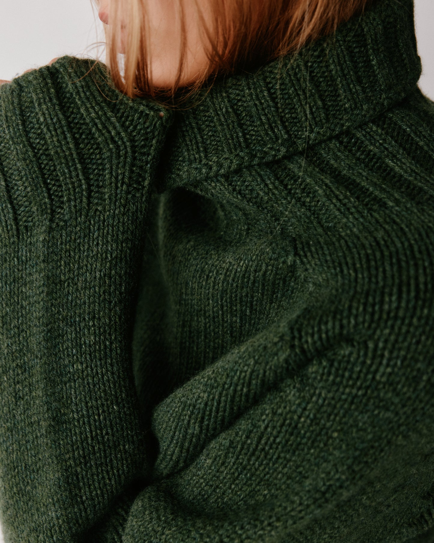 A model wearing a Bosie Blue Mogganer Womens Siren Merino Polo Neck Sweater in colour Serpentine.