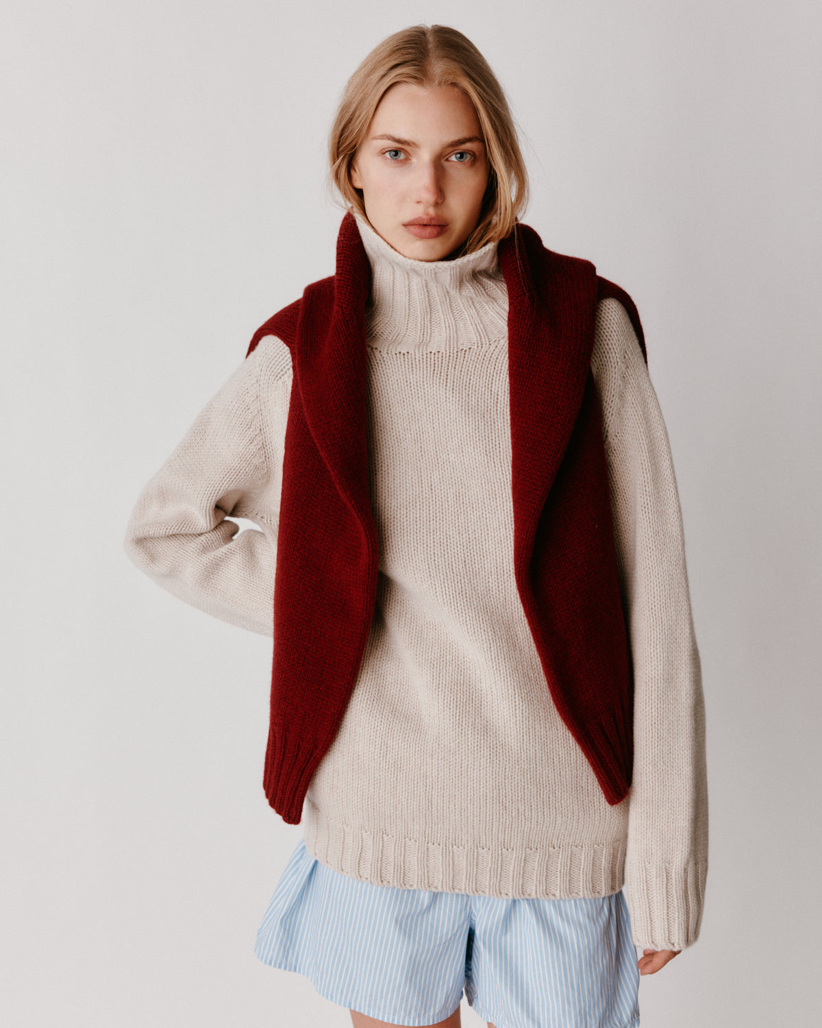 A model wearing a Bosie Blue Mogganer Womens Siren Merino Polo Neck Sweater in colour Swansdown.