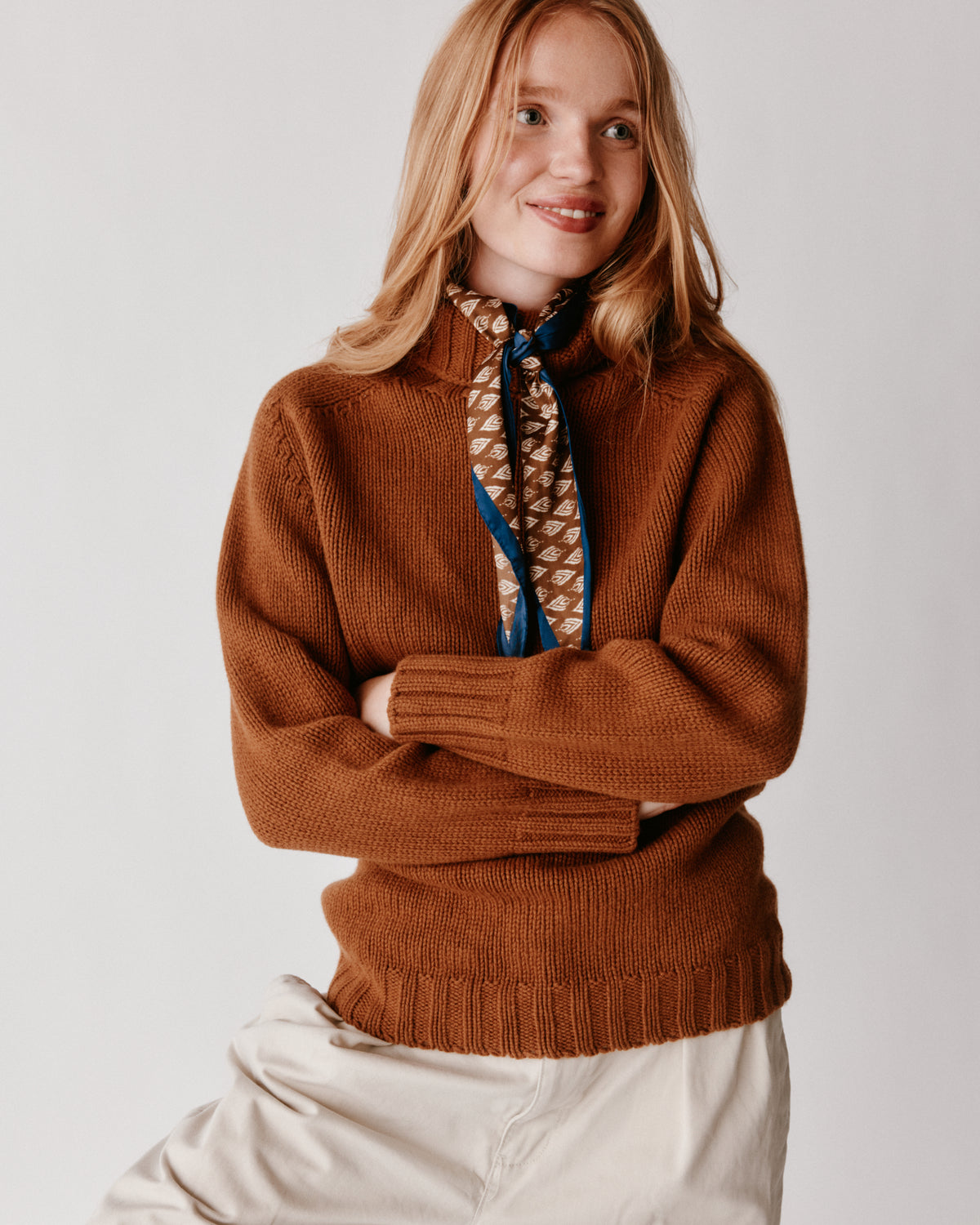 A model wearing a Bosie Blue Mogganer Womens Siren Merino Polo Neck Sweater in colour Vintage Vicuna.