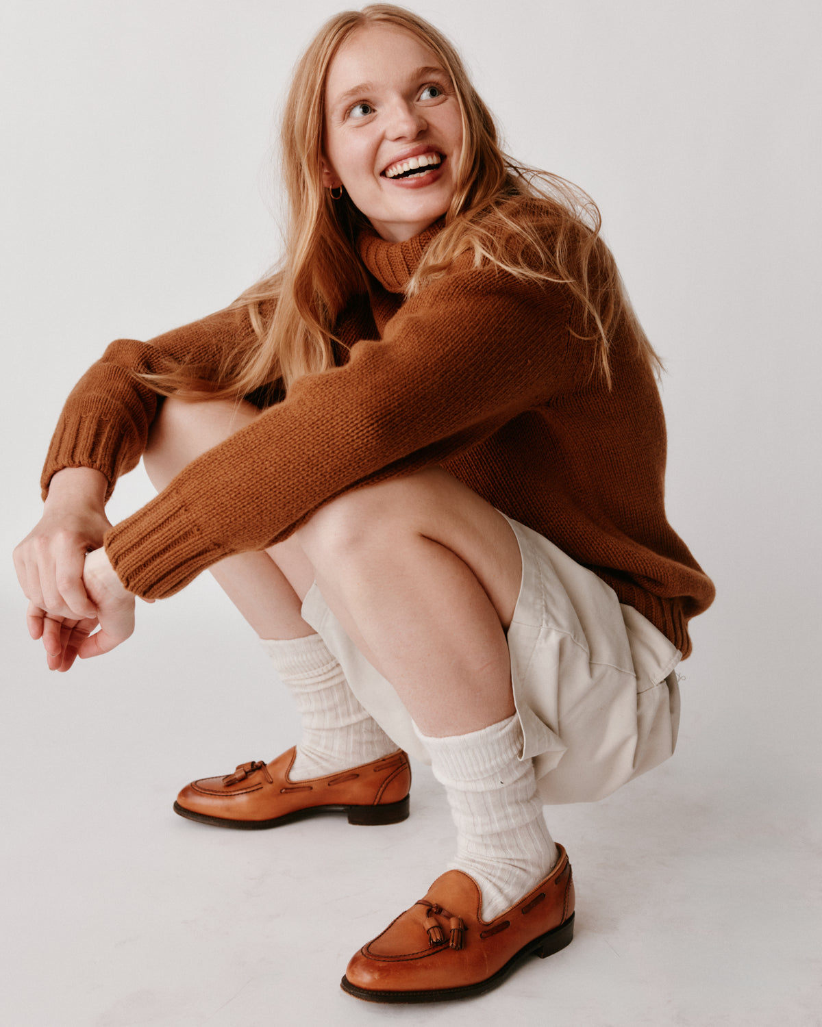 A model wearing a Bosie Blue Mogganer Womens Siren Merino Polo Neck Sweater in colour Vintage Vicuna.