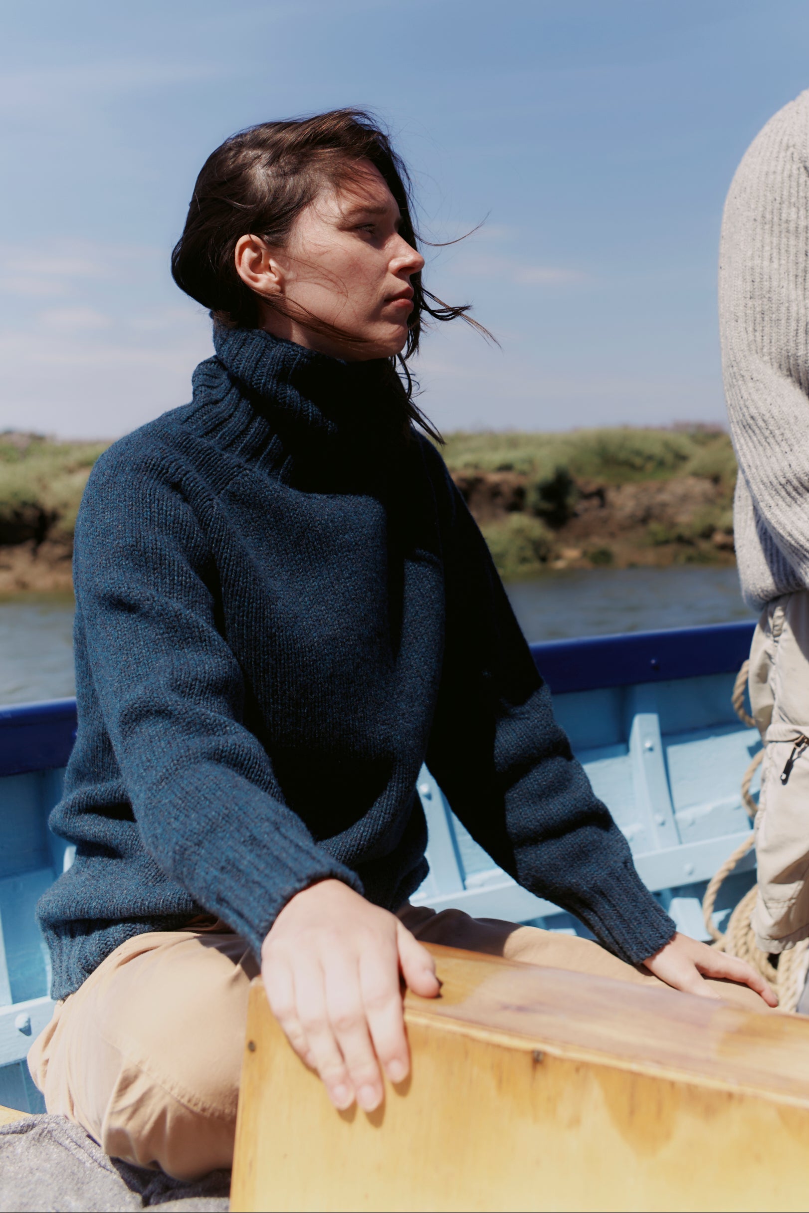 Model wearing a Bosie Knitwear Blue Mogganer Womens Siren Merino Polo Neck Sweater in colour Lugano Dark Teal.