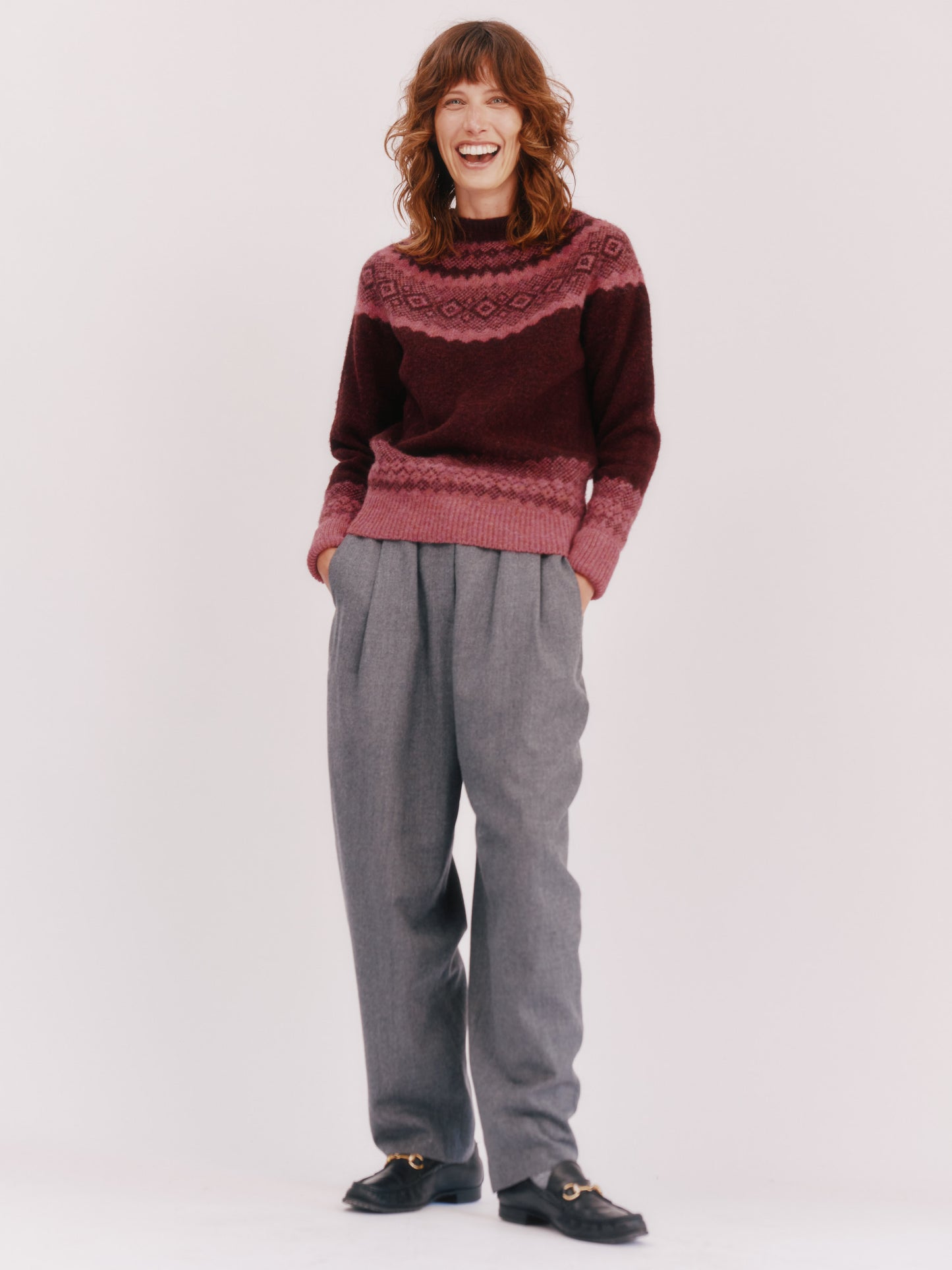 Model wearing a Bosie Knitwear Borealis Yoke Brushed Fair Isle Women's Lambswool Sweater in colour Dark Cranberry.
