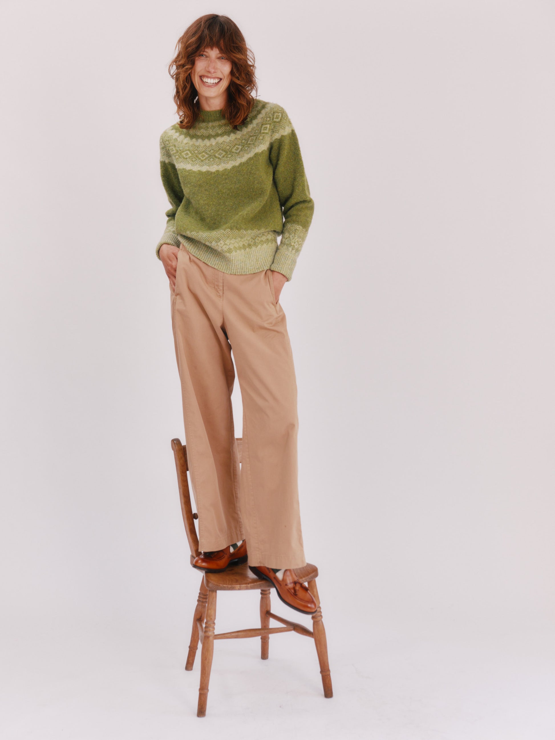 Model wearing a Bosie Knitwear Borealis Yoke Brushed Fair Isle Women's Lambswool Sweater  in colour Olive Grove Green.