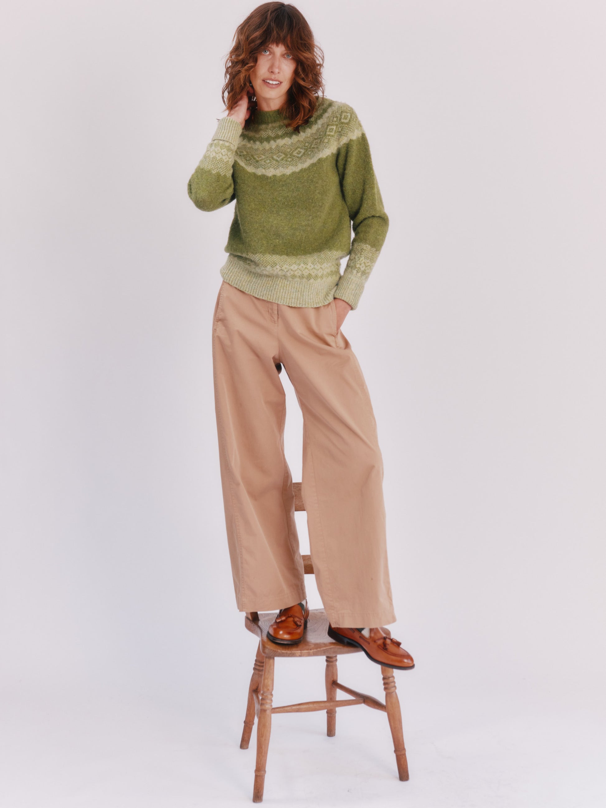 Model wearing a Bosie Knitwear Borealis Yoke Brushed Fair Isle Women's Lambswool Sweater  in colour Olive Grove Green.